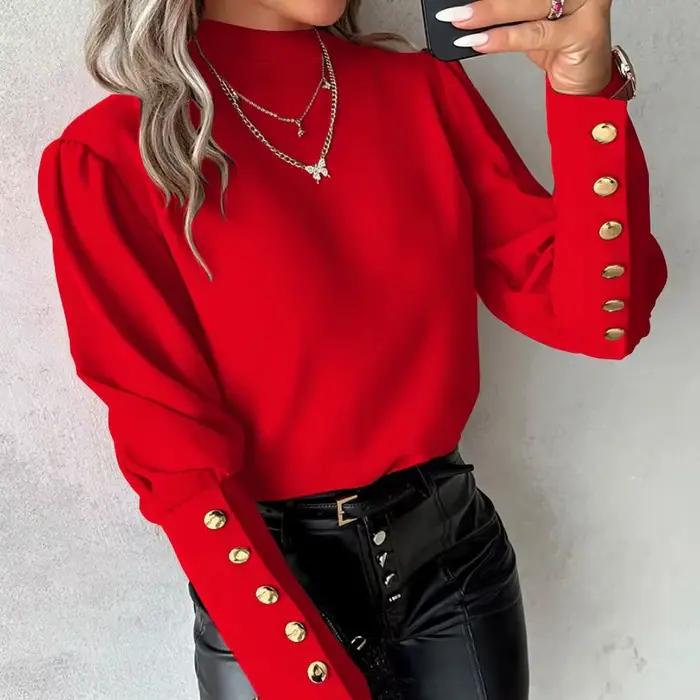 Chemise élégante à col haut et manches longues bouffantes avec boutons dorés décoratifs sur les poignets et tissu lisse